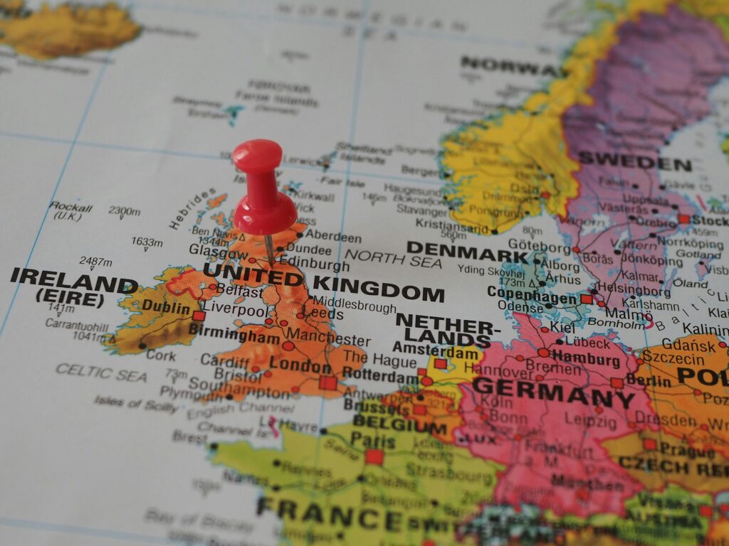 Close-up of a European map highlighting the UK with a red pin, perfect for geography themes.