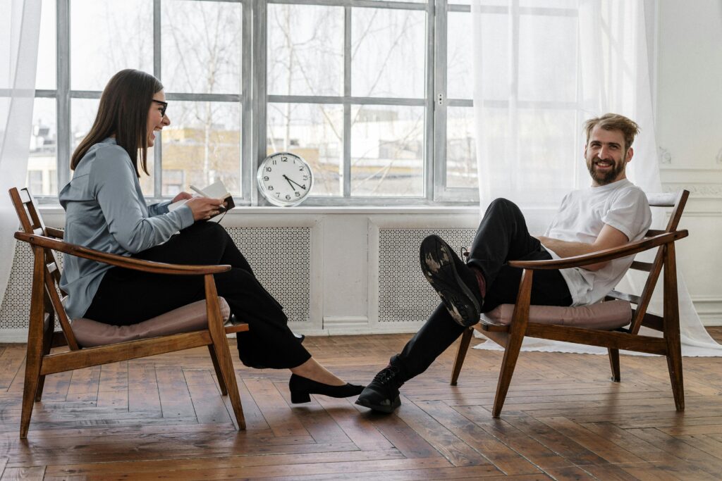 Counselor and client in a positive therapy session in a well-lit room.